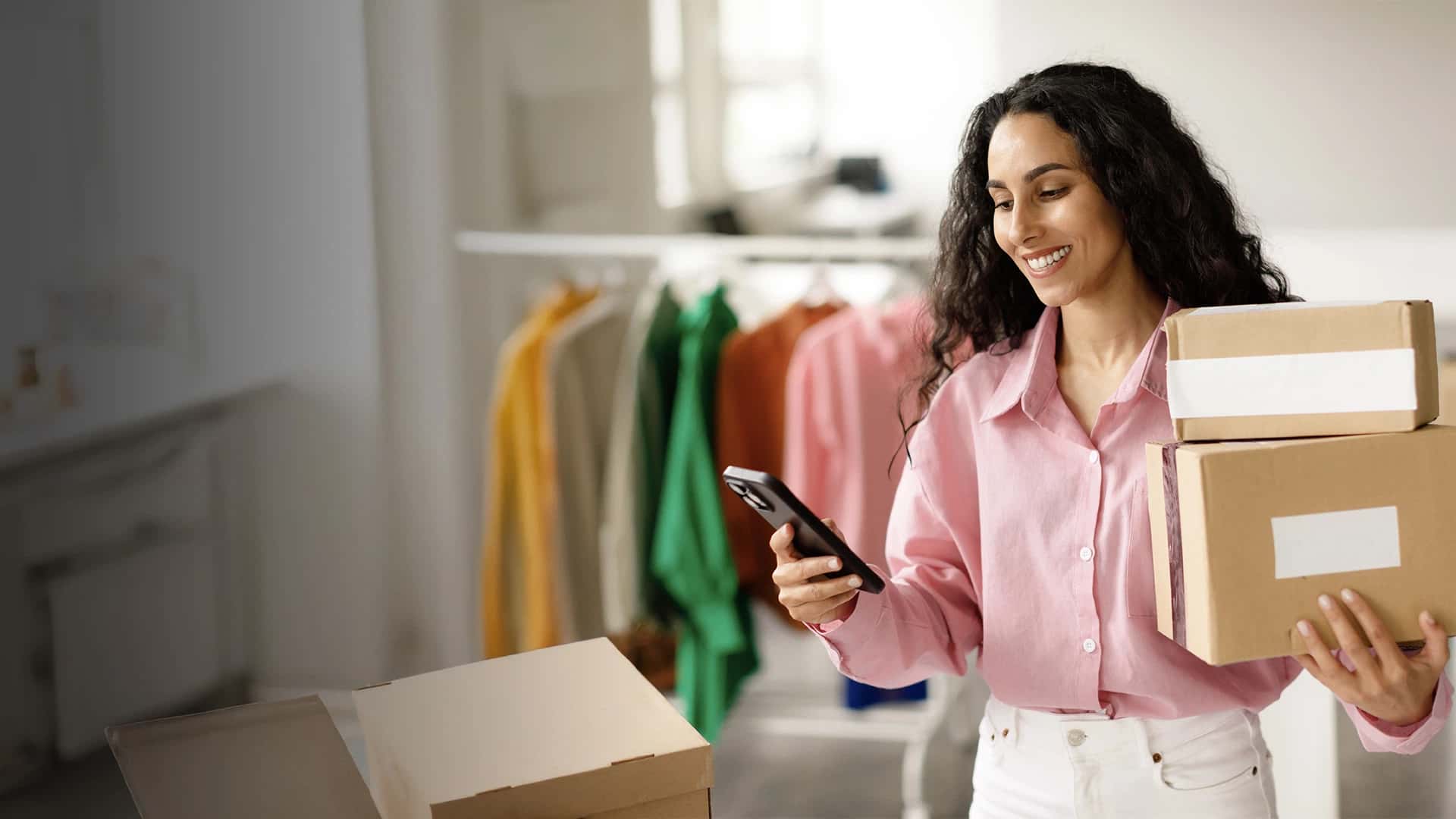 Mujer cobrando a través de su tienda online y con cajas de envíos